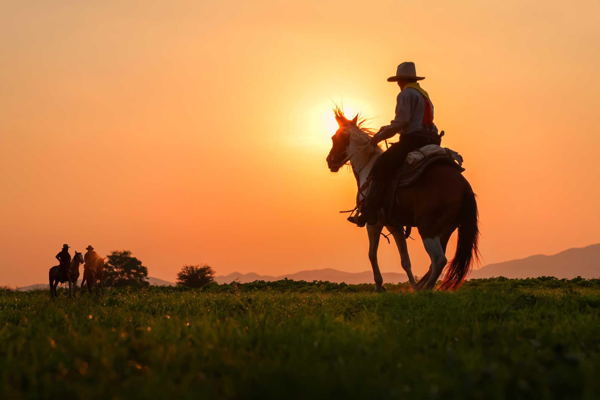 the-silhouette-of-three-men-wearing-a-cowboy-hat