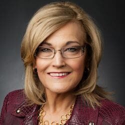 A woman wearing glasses and a burgundy jacket, providing information about Avisco Financial.